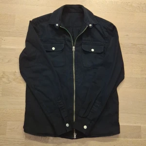 Emilio Overshirt  - Snygg svart jacka från Emilio med dragkedja och två bröstfickor med knappar. Den är lite stor i storleken så den passar även S. Om du har andra frågor är det bara att skicka ett meddelande ✅️
