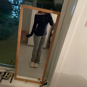 Mörkblå offshoulder topp - Snygg mörkblå offshoulder topp med lång ärm. Perfekt för en stilren look. Toppen har en tight passform och är tillverkad i ett mjukt material. 