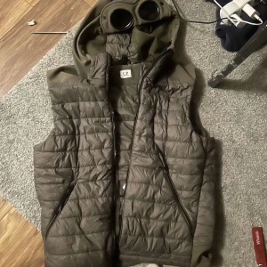  Grön Cp company väst - Tja! Säljer min cp väst på grund av att jag har köpt vinter jacka och använder inte västen längre,har haft den 3 månader inte Kötta använd på grund av vädret,fint kick och inga skador är även varm på grund av de tunga materialet på  Priset diskuteras