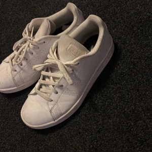 Vita sneakers från Adidas - Säljer ett par klassiska vita sneakers från Adidas. Skorna har snörning och är i en stilren design som passar perfekt till vardags. 