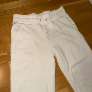 Vita mjukisbyxor 🤍 - Säljer ett par vita mjukisbyxor från 151 i storlek L. Byxorna har en bekväm elastisk midja med dragsko och praktiska fickor fram. Perfekta för en med Stockholm stil eller för en som gillar en mer basic look. Aldrig använt innan. Passar som en liten L men mer som en M. Tar bara emot Swish! Skriv vid frågor, jag skickar även postbevis☺️💕Frakt: 65kr