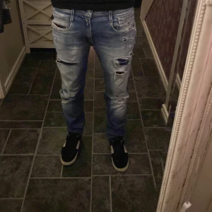  Replay jeans - Säljer ett par blå ripped jeans från Replay, modell Anbass. De har en snygg slitning och hål på framsidan för en trendig look. Perfekta för en avslappnad stil. De har hål där bak vet inte om de ska va så men inget man tänker på när man har på sig de syns inte så mycket heller