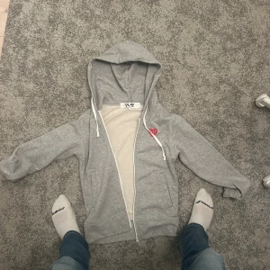 Cdg zip grå - Snygg grå zip från märket cdg. Möts upp i Stockholms området. Hoodien är lite liten i storlek, pris kan förhandlas! //Viktor