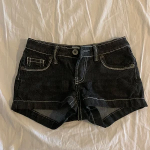 Svarta jeansshorts med broderade fickor - Säljer ett par snygga svarta jeansshorts med coola broderade detaljer på bakfickorna. De har en knapp och dragkedja fram och är i en klassisk femficksmodell. Perfekta för sommaren och passar både till vardags och fest!