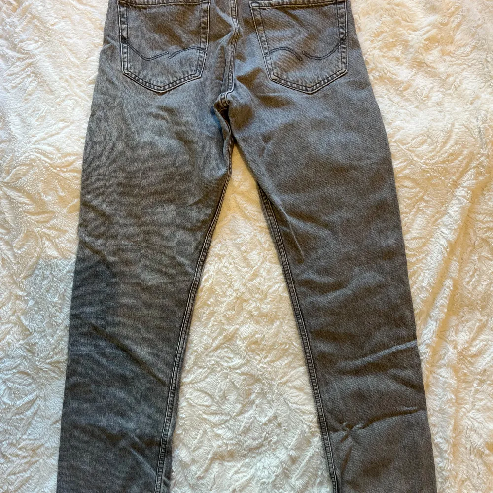 Säljer ett par grå jeans i loose fit, modell Chris. De är i storlek 27/32 och har en avslappnad passform. . Jeans & Byxor.