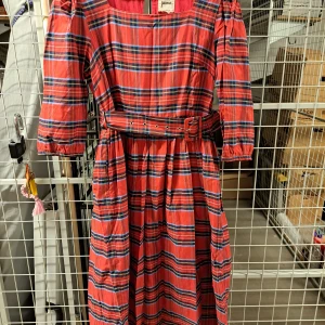 Rutig klänning från Joanie - Säljer en superfin rutig klänning från Joanie storlek 40. Den har en härlig kombination av rött, blått och svart i ett klassiskt rutmönster. Klänningen har trekvartsärmar och ett bälte i midjan för en snygg passform. Perfekt för både vardag och fest!