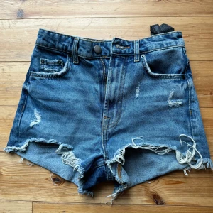 Blå jeansshorts från Zara - Säljer ett par coola blå jeansshorts från Zara. De har en snygg slitning och fransiga kanter för en avslappnad look. Perfekta för sommardagar eller festivaler! 🕶️