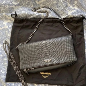 Zadig väska - Rock savage clutch väska från Zadig&voltaire. Köpt för 3900kr kom inte till så mycket användning tyvärr, därav säljer jag den. En lång kedja och dustbag medföljer.💞💞💞