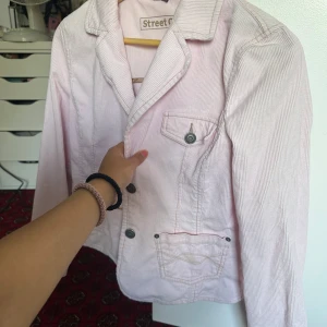 Ljusrosa kavaj från Street One - Säljer en superfin ljusrosa kavaj från Street One. Den har en klassisk krage och knappar framtill. Perfekt för vår och sommar! Kavajen har långa ärmar och en snygg passform. Den är i bra skick och redo för nya äventyr.