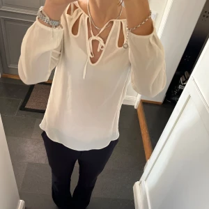 Vit blus med snörning  - Vit blus med snörning från Zara i storlek M, passar även S. Fint skick. Använd gärna köp nu!