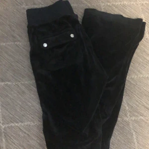 Svarta juicy couture byxor - Snygga svarta juicy couture byxor i mjukt material med silverfärgade knappar. Perfekta för en y2k look🩷