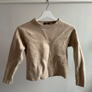Beige ulltröja från Uniqlo - Underbar tröja från Uniqlo som tyvärr har krympt i tvätten. Urpsrungligen S. Men skulle säga att den är något kort i armar och mage, för mig som normalt sätt har S eller XS. 100% ull. 