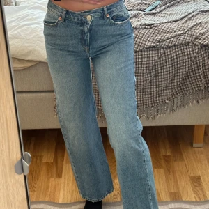 Blå jeans med rak passform - Snygga blå jeans från Pull and bear med rak passform och klassisk femficksdesign. De har en v formad knappgylf och är mid waist 