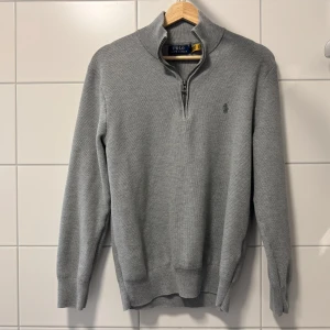 Mesh-Knit Cotton Quarter-Zip Jumper Polo Ralph Lauren - Snygg grå tröja från Polo Ralph Lauren i bomull med en praktisk dragkedja vid halsen. Perfekt för en stilren look med långärmad design och diskret logga på bröstet.