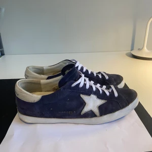 Golden Goose - Snygga blå sneakers i mocka från Golden Goose. Modell: Superstar. Skick:9/10.  Pris ej hugget i sten! Skorna är bara lite slitna under. Skriv om ni har frågor! Box kommer med!