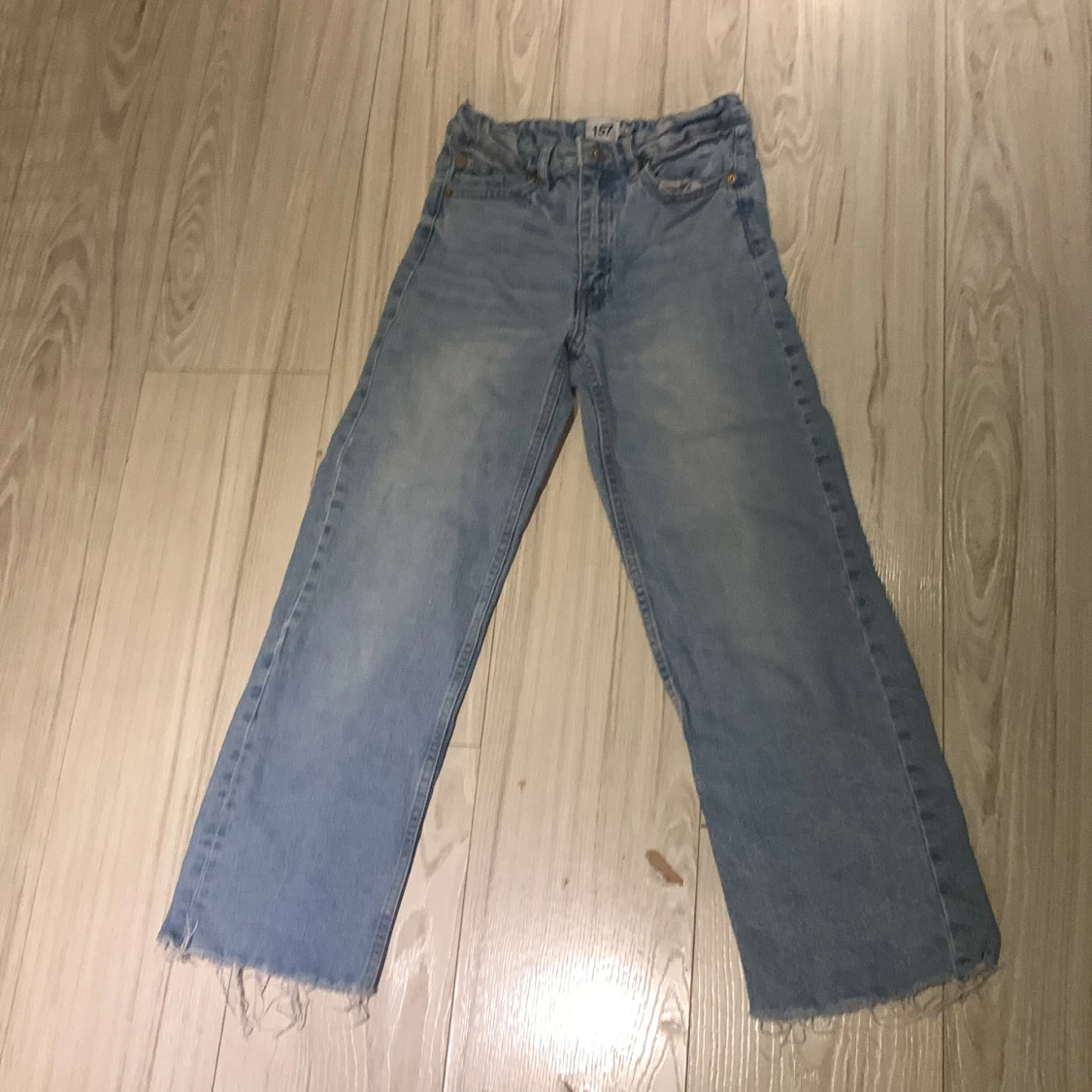 Blå jeans med fransiga kanter