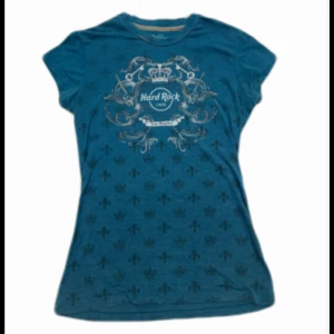 Blå t-shirt från Hard Rock Café  - Snygg blå t-shirt från Hard Rock Café med tryck både fram och bak. 