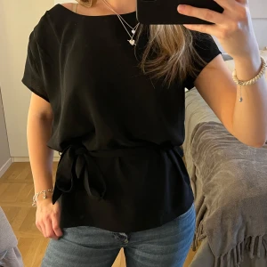 Svart blus med knytband - Jättefin svart knyttopp. Storleken är 36. Betalning sker via Swish och det är bara att höra av sig om ni undrar något🩵