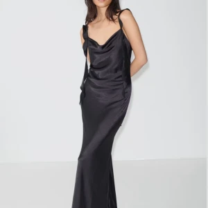 Frill-klänning - Gina tricots frillklänning i storlek 36! En svart långklänning i satin som är så stilren och elegant! Klänningen är aldrig använd och i nyskick med lappen kvar. Säljer vidare då den är lite för liten och jag har köpt en i ny storlek 💕nypris 599:-