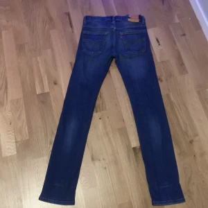 Blå jeans från Levi's - Snygga blå Levi's jeans med skinny passform. Klassisk design med fem fickor och knappgylf. Perfekta för en stilren look.