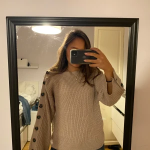 Unik stickad tröja med knappar  - Säljer min skitsnygga stickade tröja med knappar på ärmarna!! Väldigt unik och svår att få tag på. Perfekt till vinter och vår!❤️ Skriv för frågor eller fler bilder💕