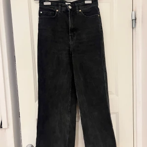 Svarta jeans från H&M - Snygga svarta jeans från H&M i storlek 36. De har en klassisk femficksdesign och är högmidjade för en bekväm passform. Perfekta för en stilren look. Finns dock ett märke på framsidan som jag inte lyckades få bort men den är inte jättesynlig.