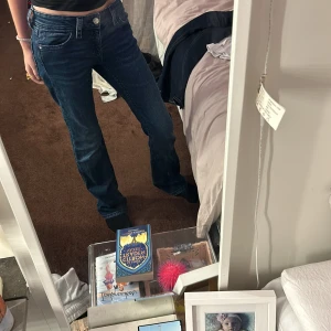 Mörkblå jeans från Gina Tricot - Snygga mörkblå jeans från Gina Tricot med klassisk femficksdesign och knappgylf. Perfekta för en avslappnad stil. De har en rak passform som ger en tidlös look.