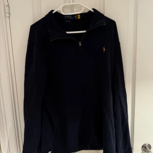 Mörkblå tröja från Ralph Lauren - Säljer en sjukt snygg halfzip från Ralph Lauren. Skicket är 9/10 utan defekter. Tveka inte att höra av dig vid frågor