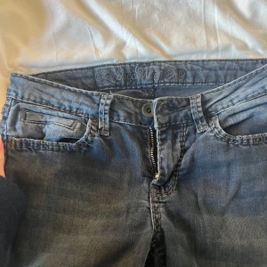 Mörkblå jeansbyxor - Snygga mörkblå jeans med klassisk femficksdesign och knappgylf. Perfekta för en avslappnad stil. De har en diskret tvättad look och är gjorda i ett slitstarkt material.