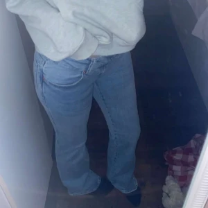 Blå jeans med broderad detalj - Snygga blå jeans med en broderad detalj på bakfickan. De har en klassisk passform och är perfekta för en avslappnad stil. Jeansen har en normal midja och raka ben.