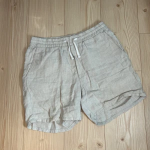Beige shorts från Weekday - Säljer ett par snygga linneshorts från Weekday. De är i storlek M och har en elastisk midja med dragsko för bästa passform. Shortsen har två sidofickor och en bakficka. Använda ett fåtal gånger. pris går att diskuteras.