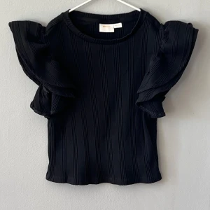 T-shirt  - Svart T-shirt med puffärm. 