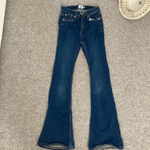 Blå bootcut jeans från Lager157 - Säljer ett par snygga blå flaired jeans från Lager157 i storlek XS. De är i bra skick och har en klassisk femficksdesign med knappar och dragkedja. Perfekta för både vardag och fest!