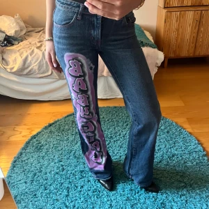 Blå jeans med rosa text från Jaded London - Säljer ett par såå snygga blå jeans från Jaded London❤️‍🔥❤️‍🔥 Så unika och perfekta till fest! skulle säga att de har en utsvängd modell med låg midja!