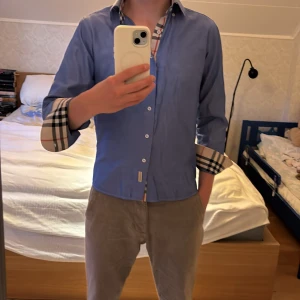 Burberry Skjorta - Säljer nu min feta blå Burberry skorta för ett väldigt rimligt pris. Osäker kring äkteheten på plagget. Skick 8/10 Den är väl omhändertagen men tyget känns lite slitet men det finns inget synligt fel med skortan. Size S passar bra i längd för mig 175 dock lite kort i ärmarna. 