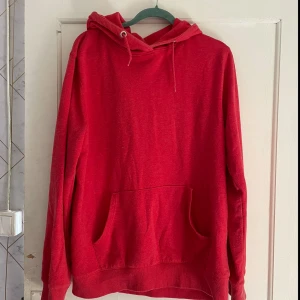 Röd hoodie från 157 - Säljer en röd hoodie från 157 i storlek XL. Den är superbekväm och perfekt för kyliga dagar. Hoodien har en stor ficka på magen och en justerbar huva med snören. Perfekt för både vardag och chill! 😎
