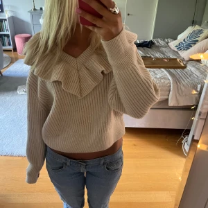 Stickad tröja med volang - Sjukt snygg stickad tröja med volang runt halsen. Knappt använd 