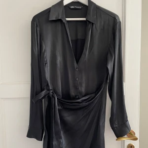 Klänning svarta - Svart mini🖤 Snygg! Men för tight för mig som ligger mellan 38/40 och D kupa Bra skick, enda ”skadan” är ett av knapphålen som är lite trådigt men inget man tänker på enligt mig.  Obs jag har sport-bh på just denna bild då den har en djup urringning 