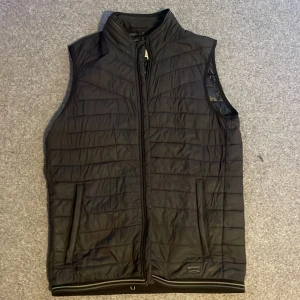 Jack & Jones väst - En Jack & Jones väst i storlek M den är använd och det syns på t.ex lappen inuti västen men inga ytliga eller innerliga skador