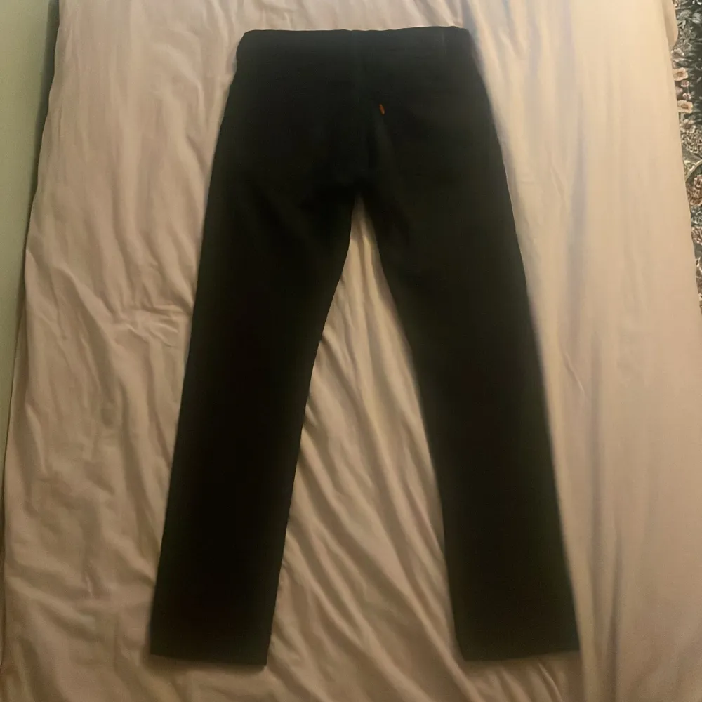 Säljer ett par svarta jeans i storlek W30 L32. De är i bra skick och har en klassisk design med fem fickor och knappgylf. Perfekta för både vardag och fest!. Farkut & Housut.