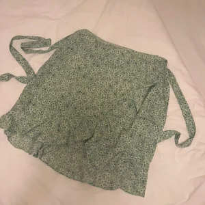 Wrap skirt - Vero Moda - Blommig jättefin ljusgrön kjol från Vero Moda, endast använd en gång och är därför i nyskick. Pris kan diskuteras. Den är i storlek XL men den sitter bra på mig som vanligtvis bär storlek M