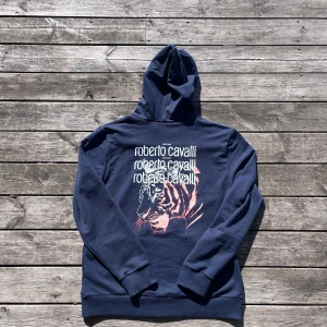 Roberto Cavalli Hoodie - Säljer en sjukt snygg Roberto Cavalli i dunderskick! Enda flawet på tröjan är att jag tagit bort ”handtaget” på zip-uppen (kolla sista bild) Nypris på denna tröja är 4100kr medans jag säljer den för 599kr