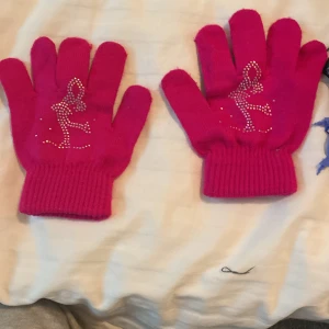 Kånståknigs vantar  -  Skrikrosa konståkning vantar med silver pärlor formade som en konståkare 