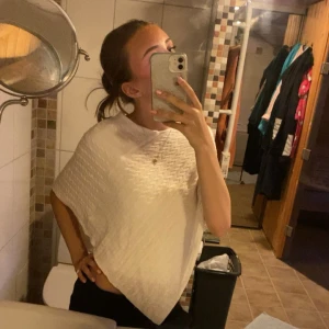 Vit poncho - Jättefin vit poncho med fina detaljer och passar perfekt över en t-shirt eller linne. Super mysig och enkel. Perfekt till sommaren! Har aldrig används heller. Står ingen storlek men passar på mig XS/S.