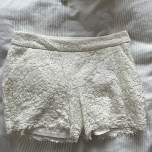 Vita spets shorts från Amisu - Säljer ett par superfina vita shorts från Amisu i storlek 38. De är täckta med vacker spets och har en elegant look. Perfekta för sommarens alla fester eller en dag på stan. De har en bekväm passform och är i nyskick. Passa på att fynda dessa stiliga shorts!