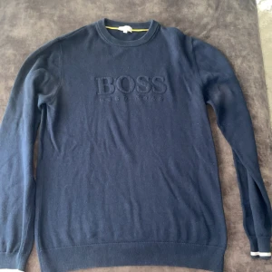 Mörkblå tröja från BOSS - Säljer en stilren mörkblå tröja från BOSS. Knappats använd då den inte passade och är i skick som ny. (Pris kan diskuteras)