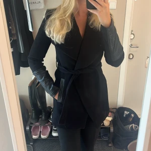 Kappa med läderdetaljer  - Supersnygg kappa med läderdetaljer vid fickorna o på armarna. Otroligt skön o varm! Har tyvärr vuxit ur den så knappt använd