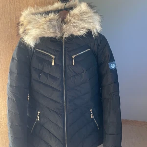 Dunjacka  - Dunjacka från Hollies i fint skick  Storlek 42  Svart  Avtagbar Pälskrage på huvan 