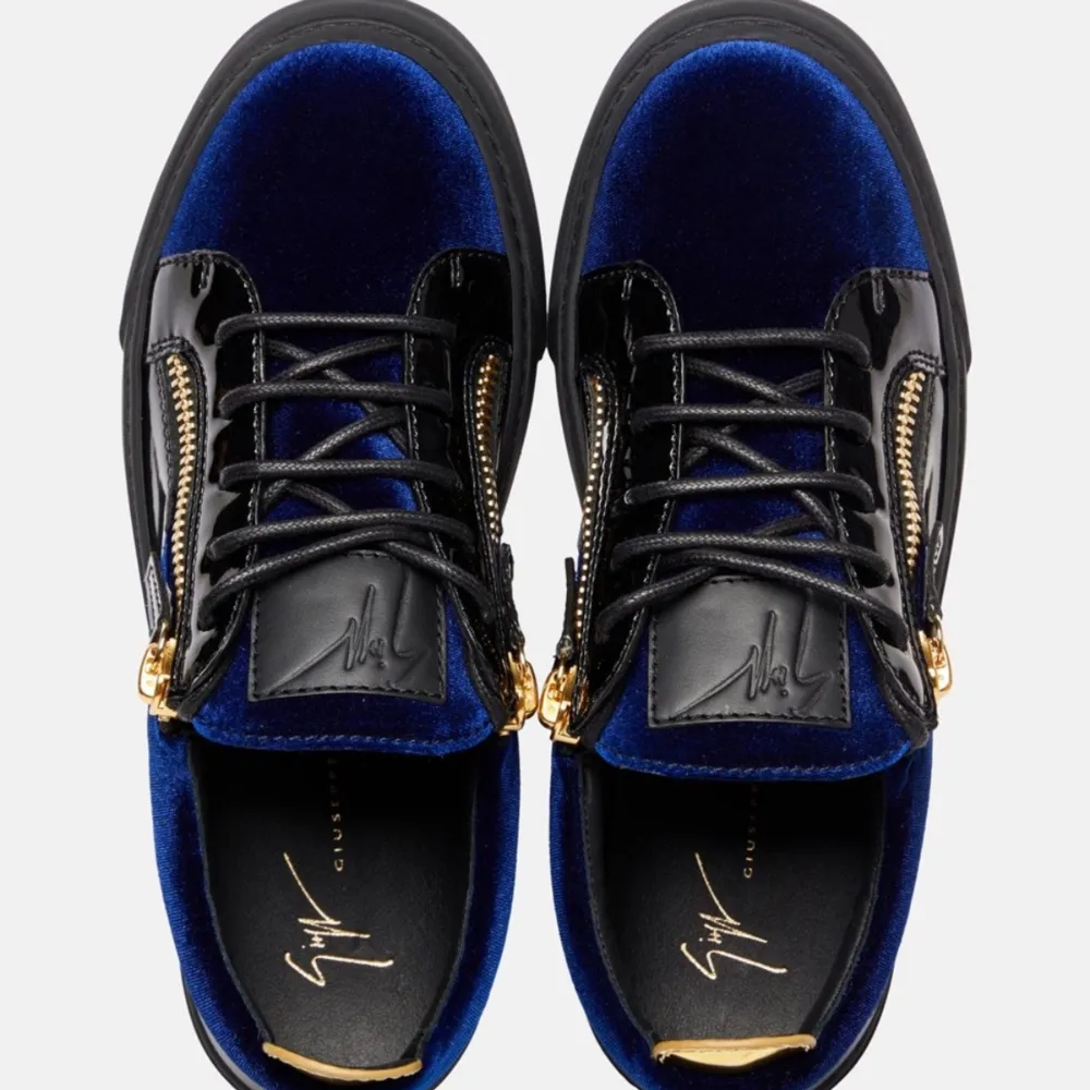 Snygga giuseppe zanotti skor som är oanvända i svart och blått med en cool design. Skorna har en kombination av glansigt skinn och blå sammet, vilket ger dem en unik look. De har snörning och en guldfärgad dragkedja på sidan för extra stilpoäng. Perfekta för att lyfta vilken outfit som helst!. Skor.