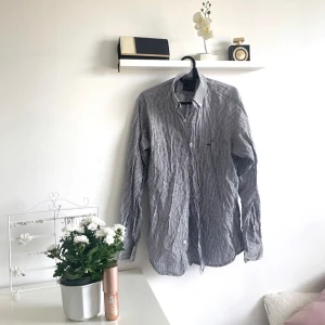 Randig skjorta - Säljer en stilren randig skjorta i blått och vitt. Perfekt för både vardag och festliga tillfällen. 